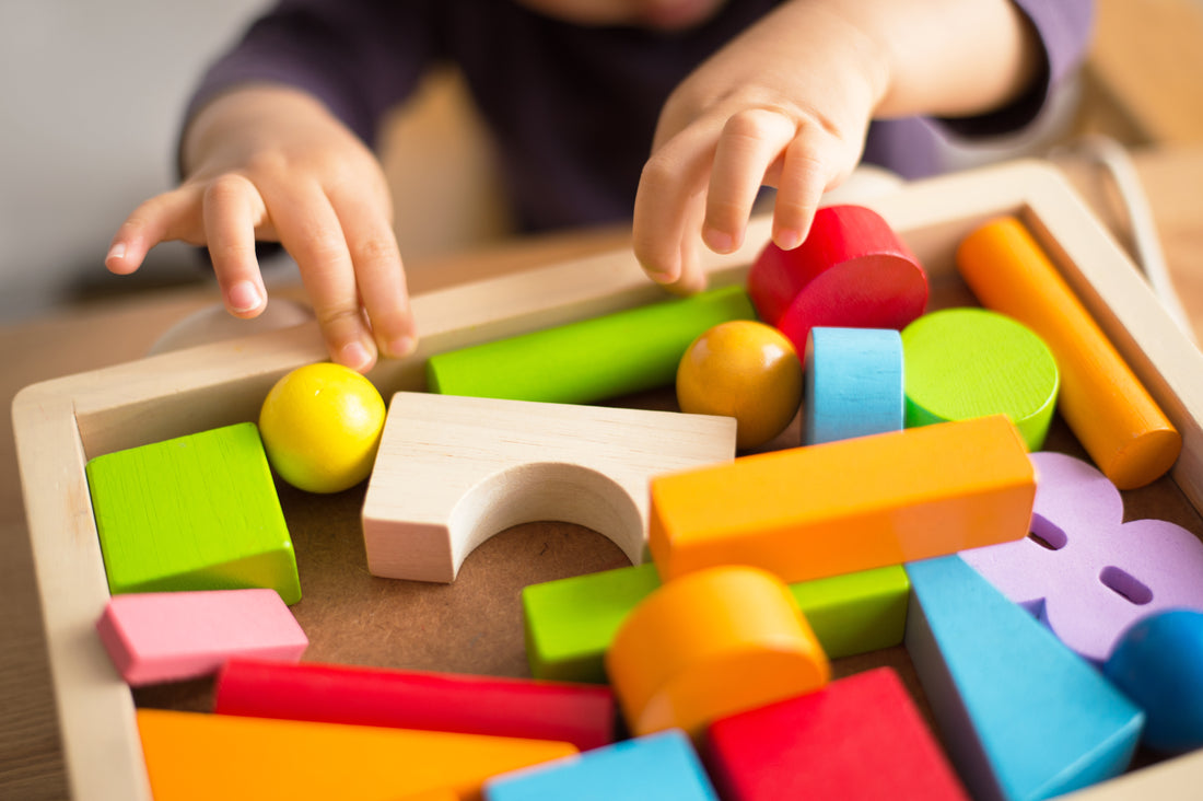 Des mains d'enfant qui semble jouer avec des cubes de construction colorés